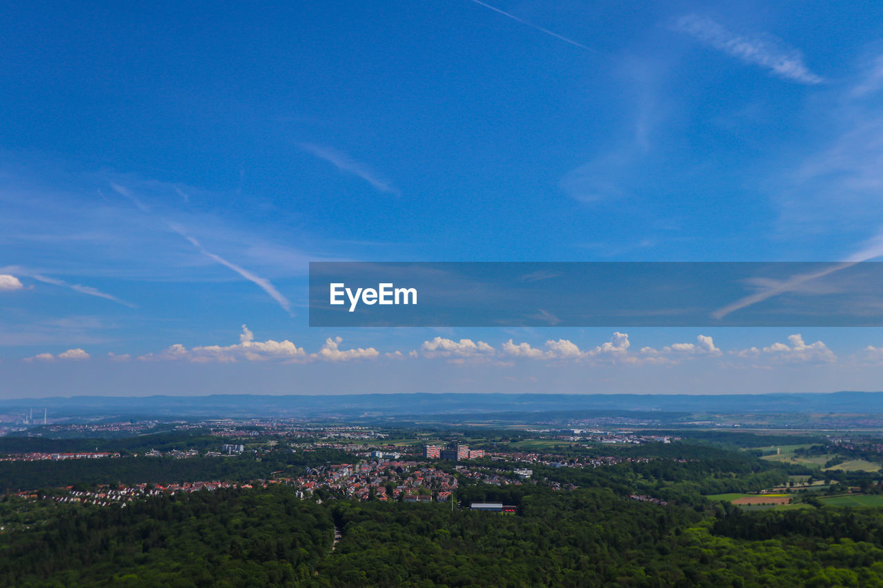 Aerial view of cityscape against blue sky