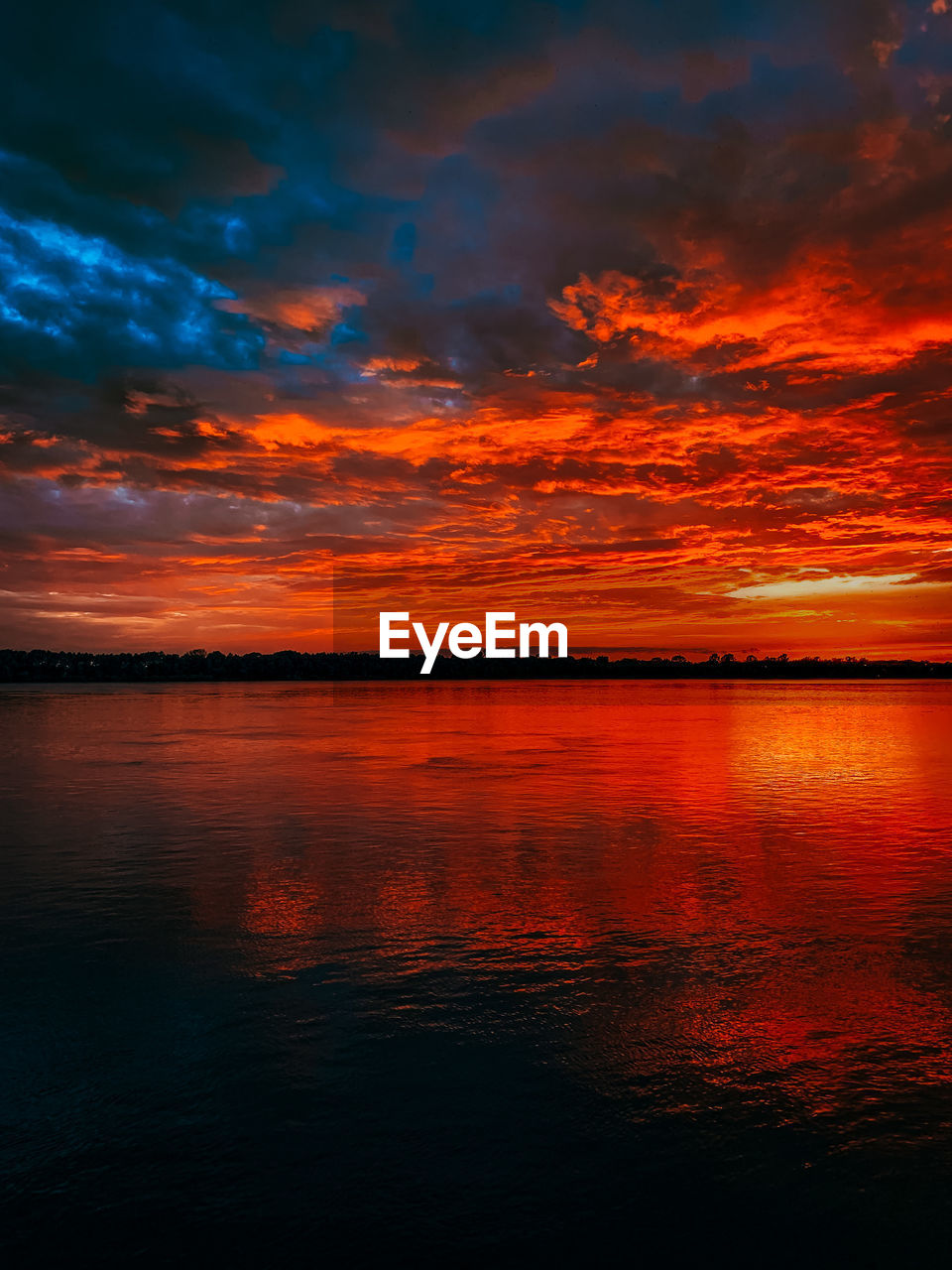 Scenic view of sea against dramatic sky during sunset