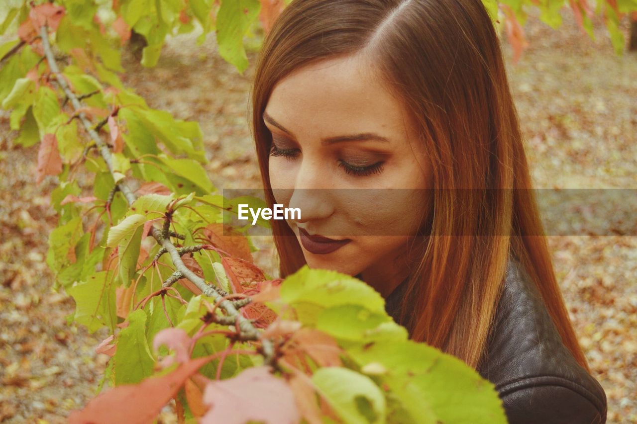 CLOSE-UP OF YOUNG WOMAN IN PLANT