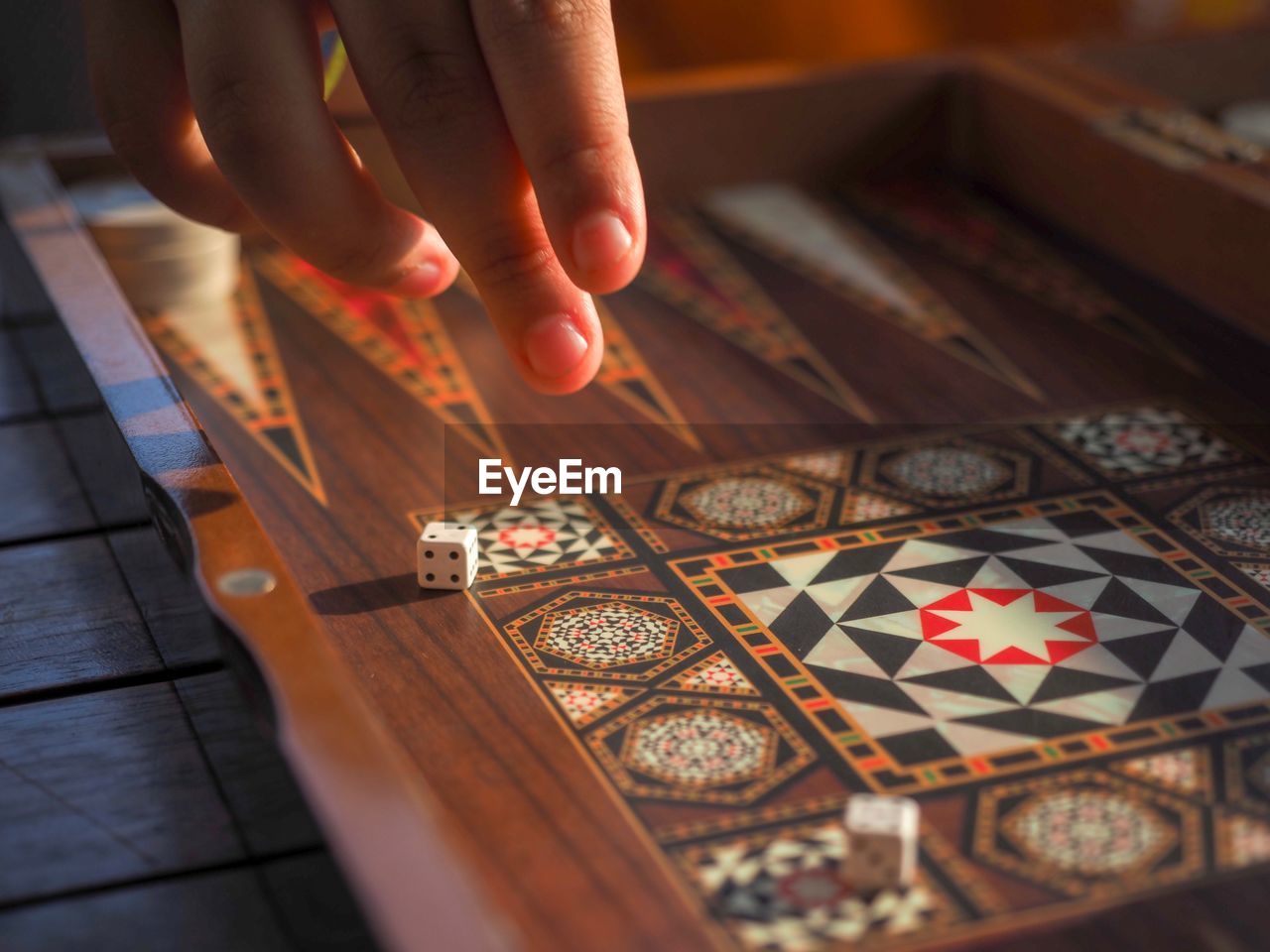 Cropped hand on person by dice on board game