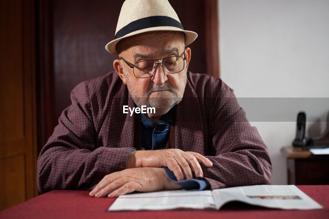 View of senior man reading at table