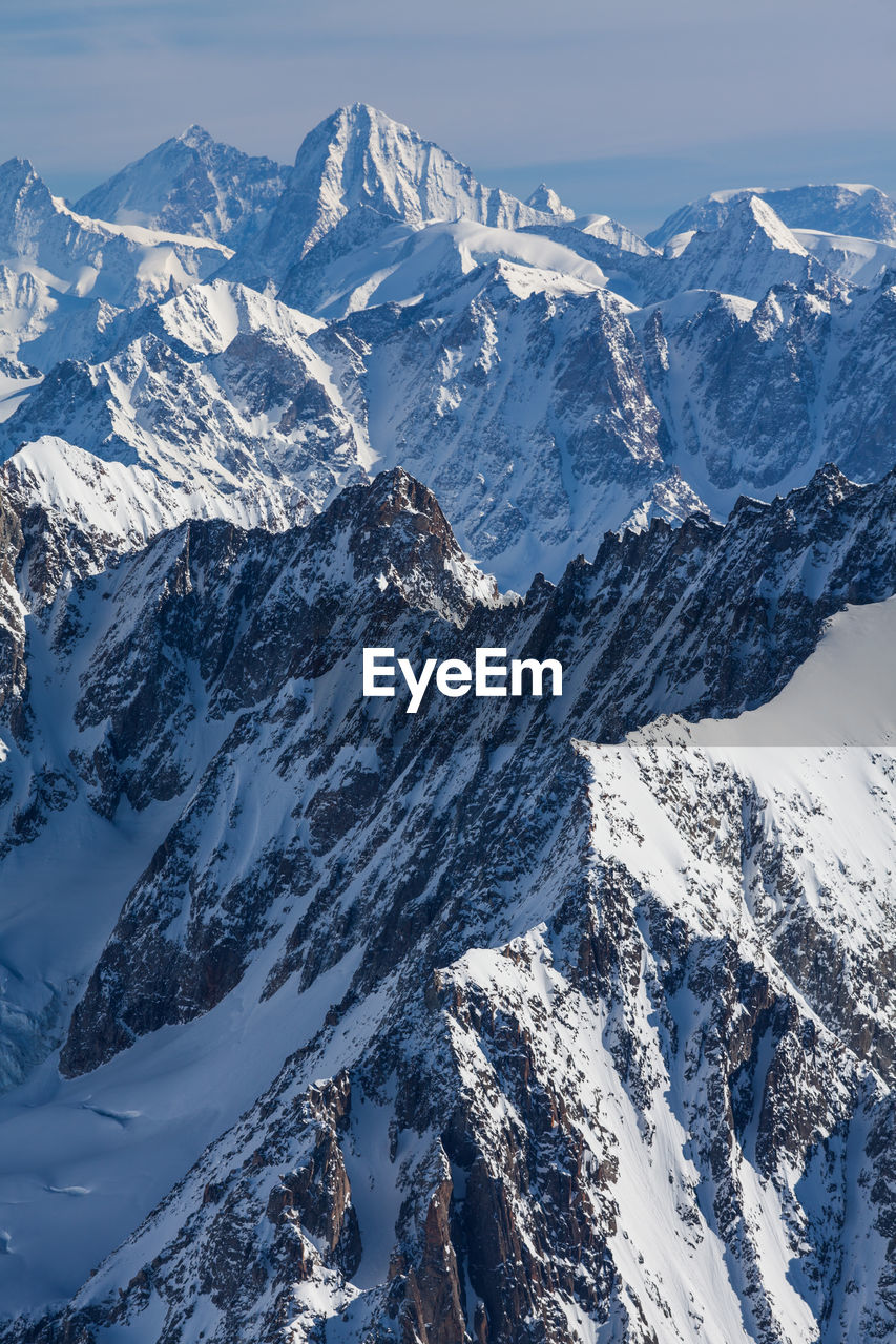 Scenic view of snowcapped mountain against blue sky