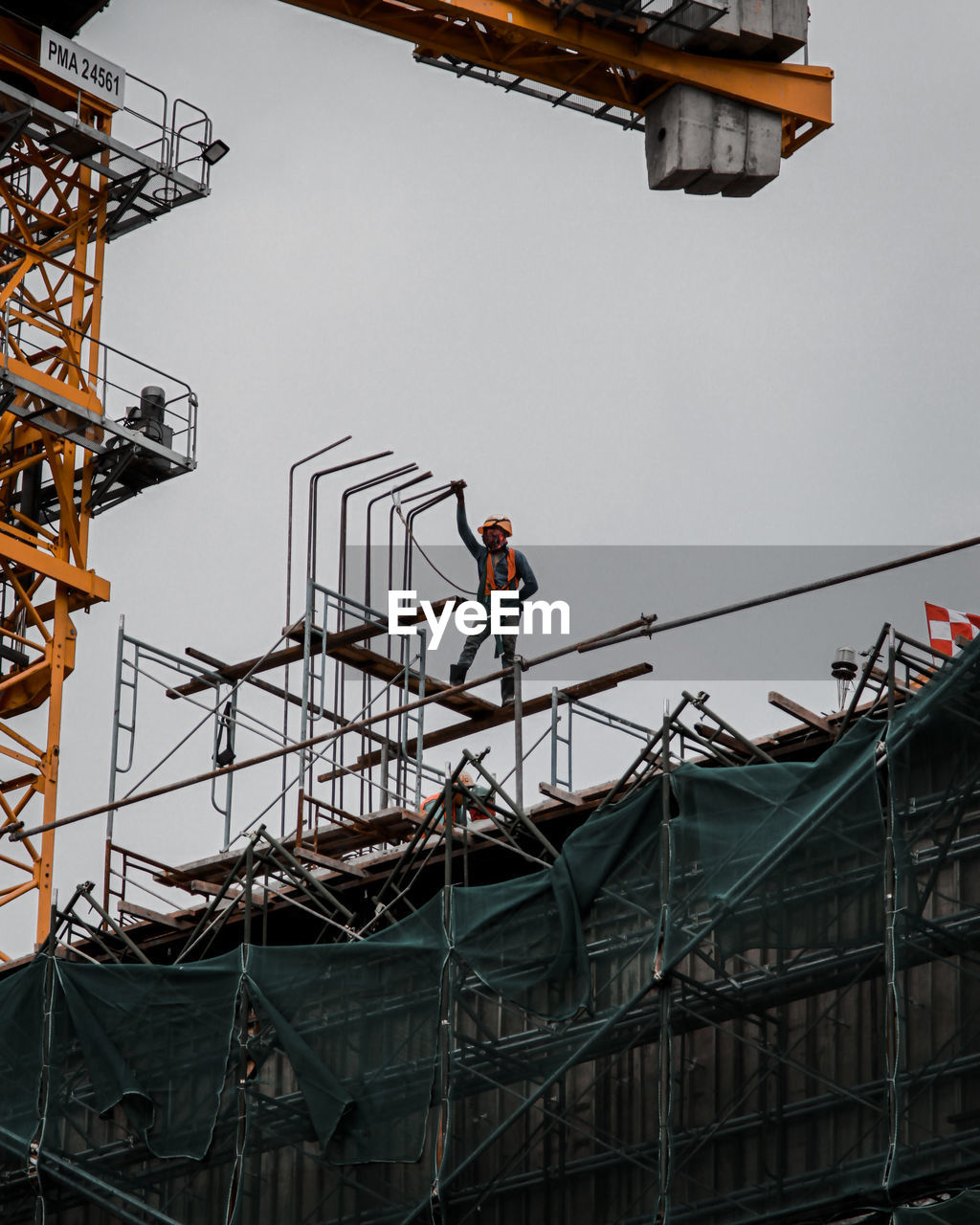 Low angle view of worker working at construction site against clear sky