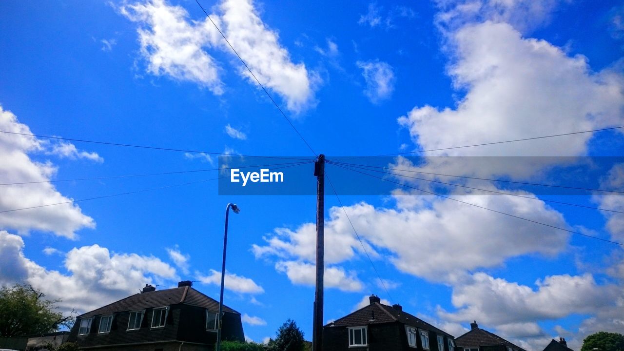 Low angle view of power line against blue sky