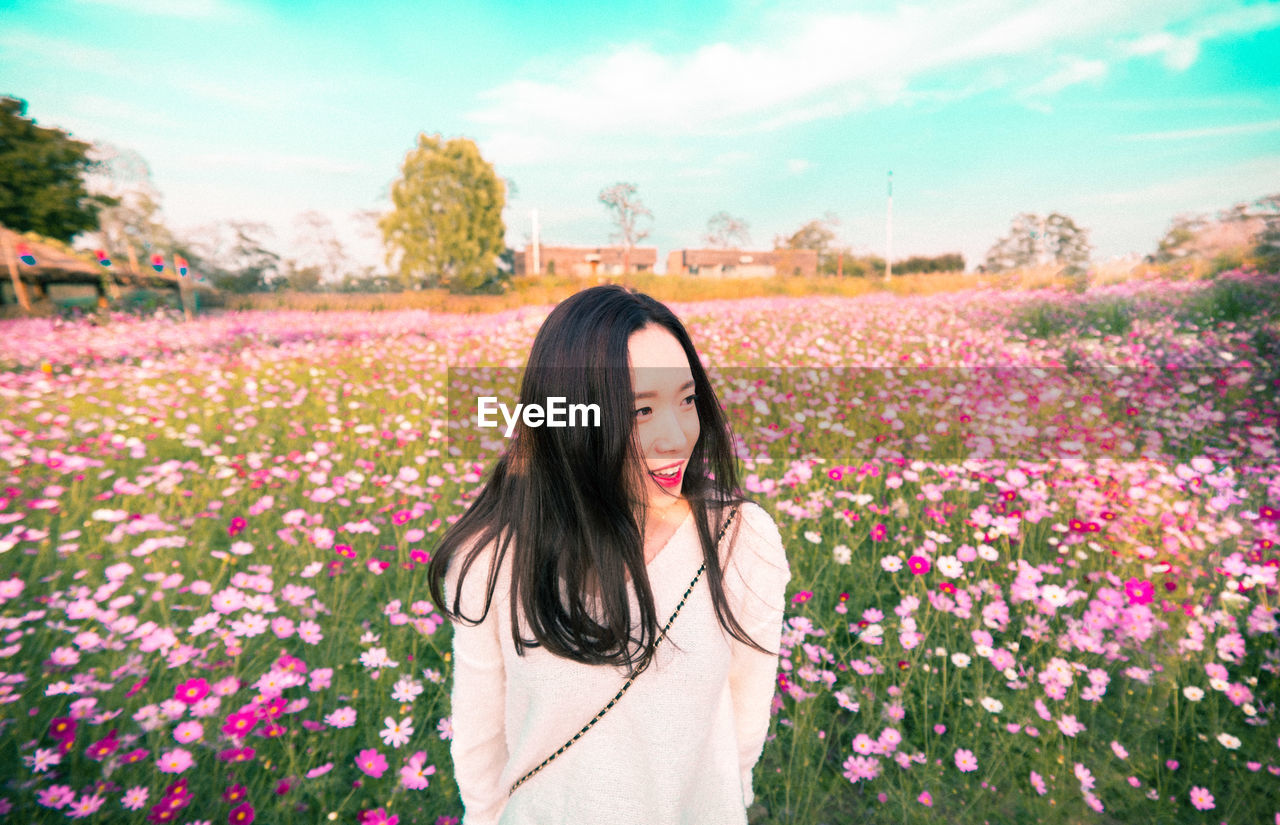 Young woman against flowering field