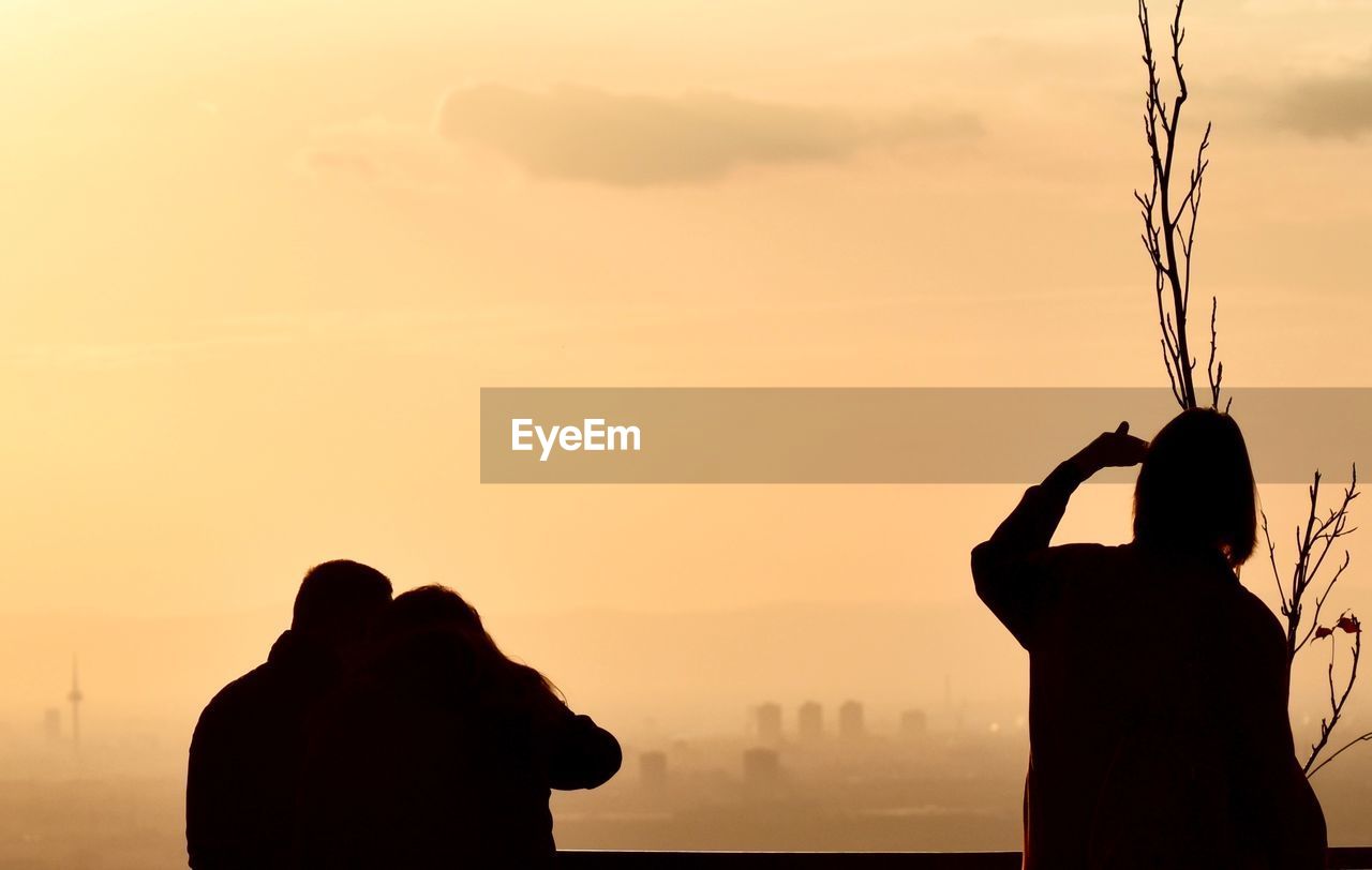 Silhouette people against sky during sunset