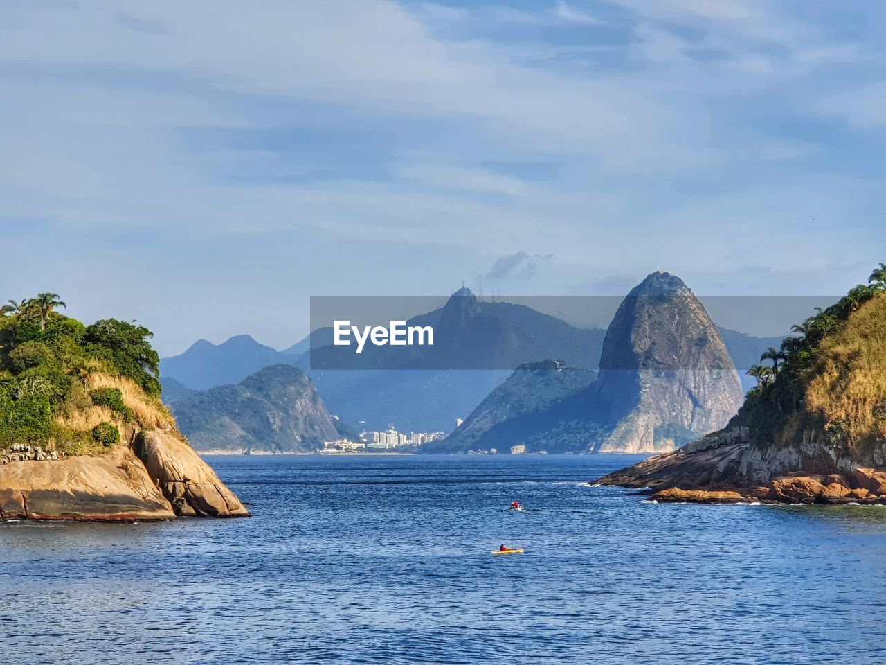 Scenic view of sea and mountains against sky