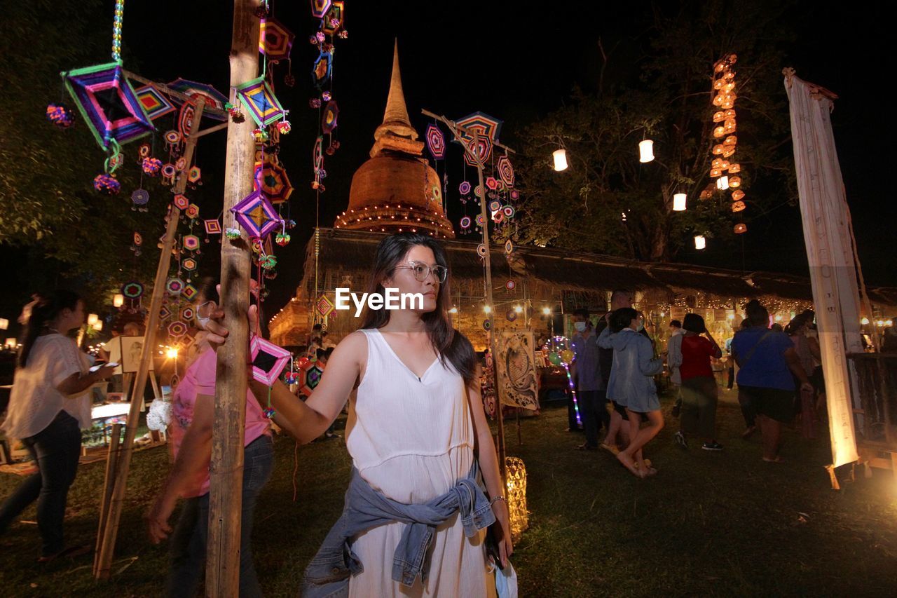 GROUP OF PEOPLE STANDING ON ILLUMINATED WALKWAY