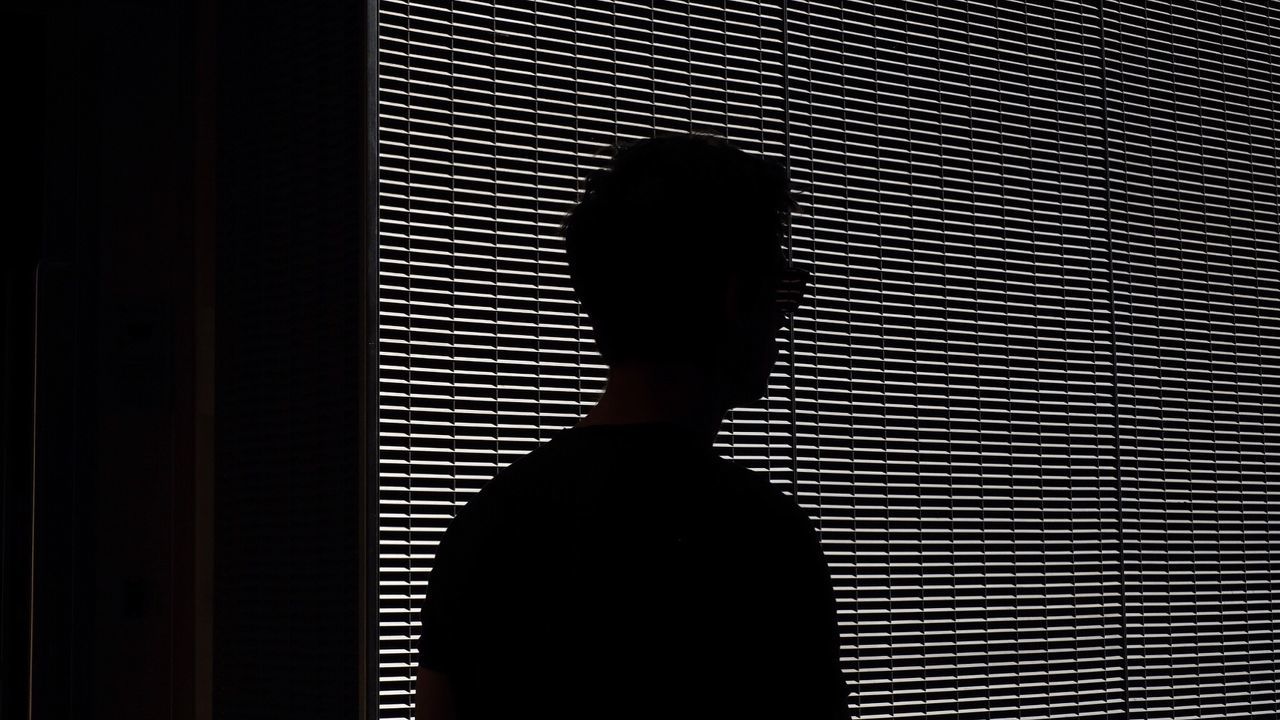 Silhouette man standing against window