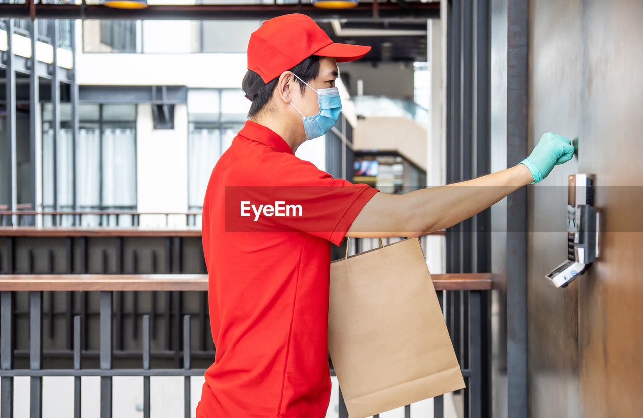 SIDE VIEW OF A MAN WORKING WITH RED UMBRELLA