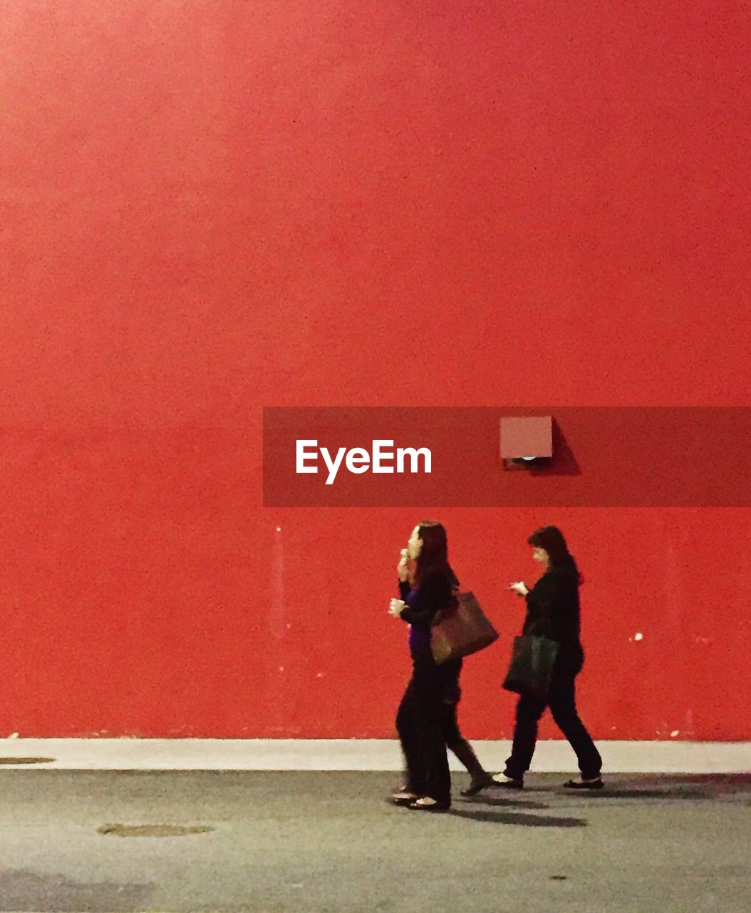 PEOPLE STANDING ON RED WALL