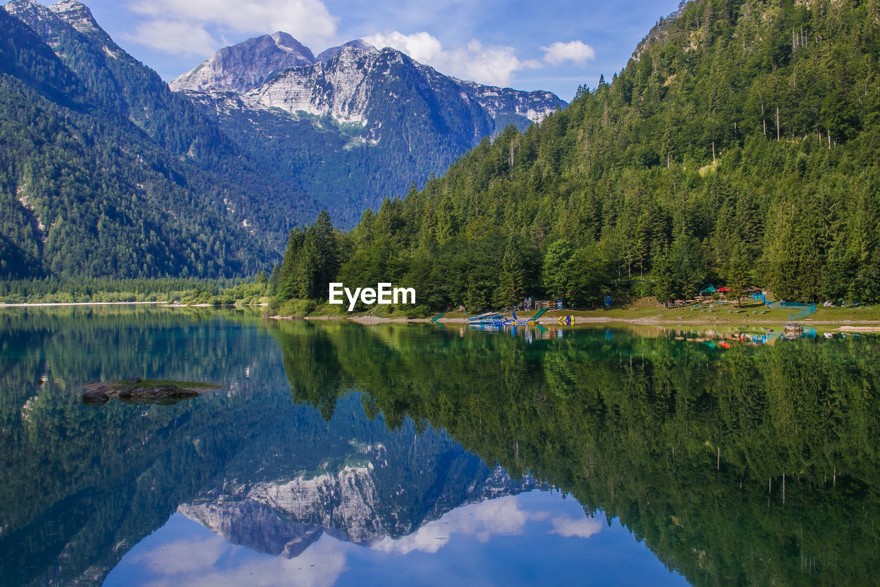 Scenic view of lake by mountains against sky