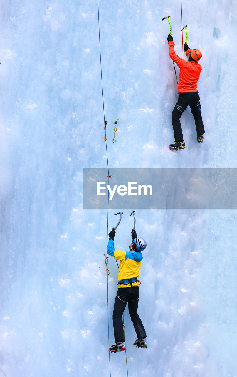Rear view of people ice climbing