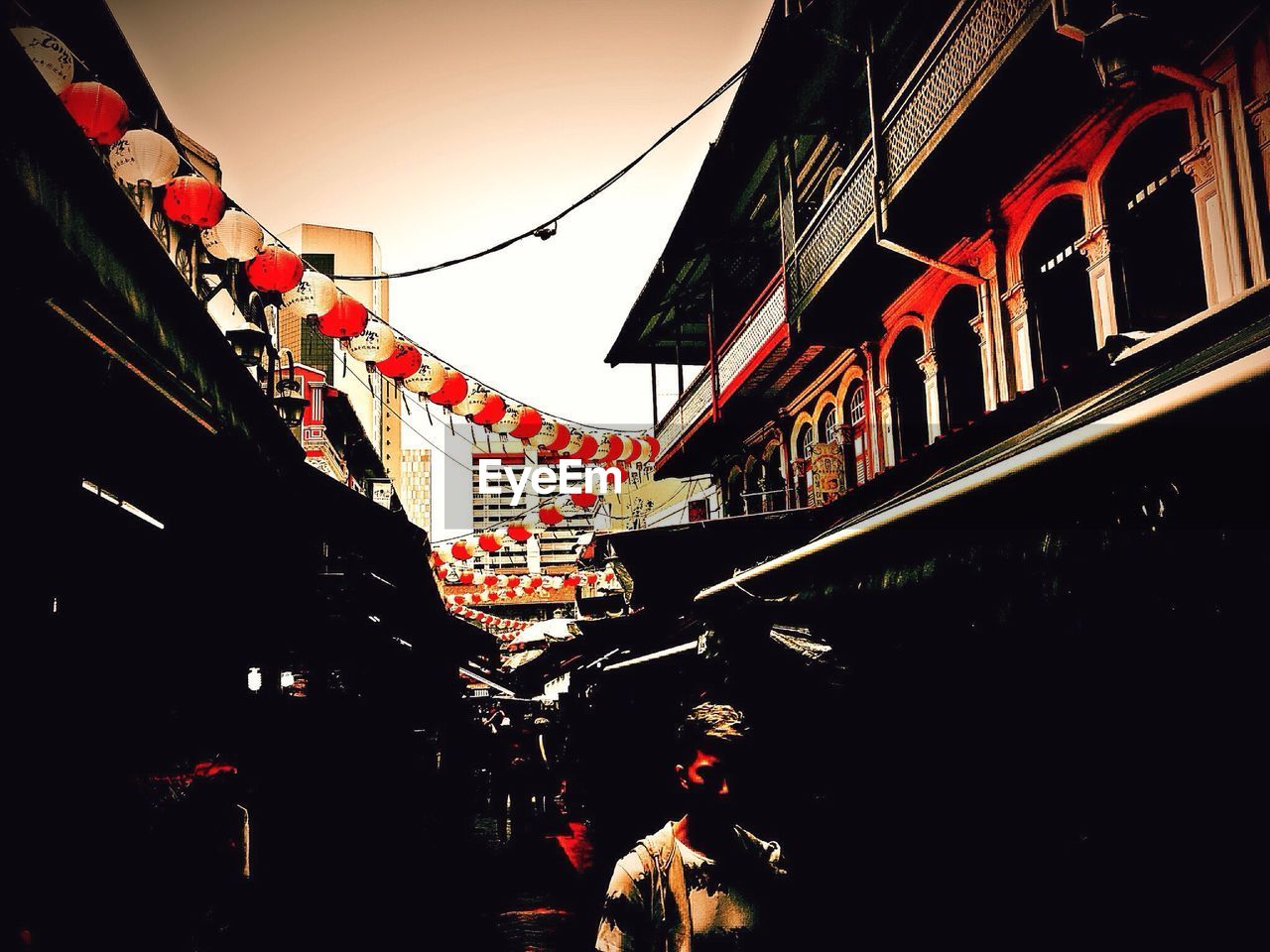 Low angle view of lanterns hanging against sky in city