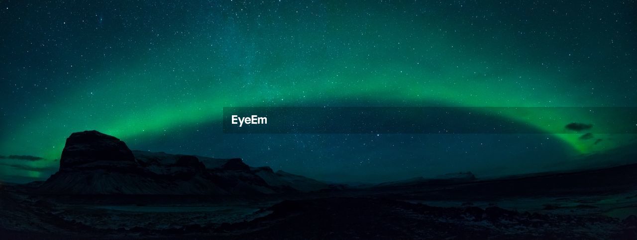 Scenic view of mountains against aurora borealis