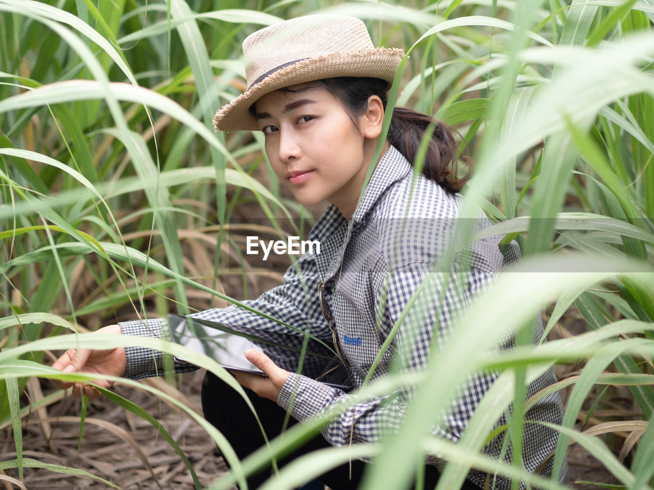 PORTRAIT OF YOUNG WOMAN WITH HAT ON PLANTS