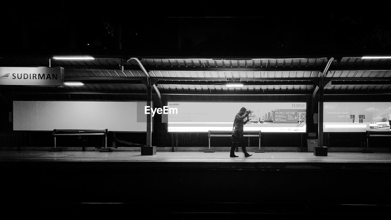 WOMAN STANDING ON RAILROAD STATION