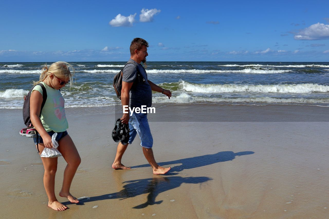 Father and daughter walking at beach