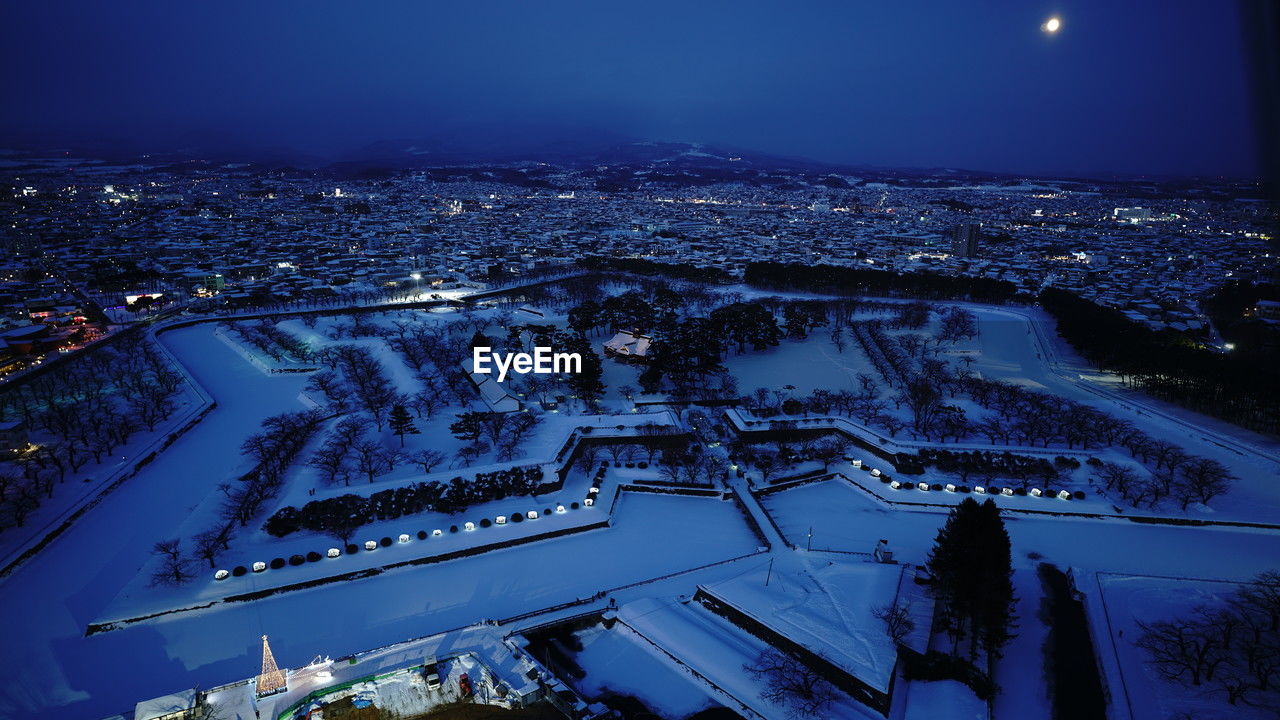 high angle view of illuminated cityscape against sky at night