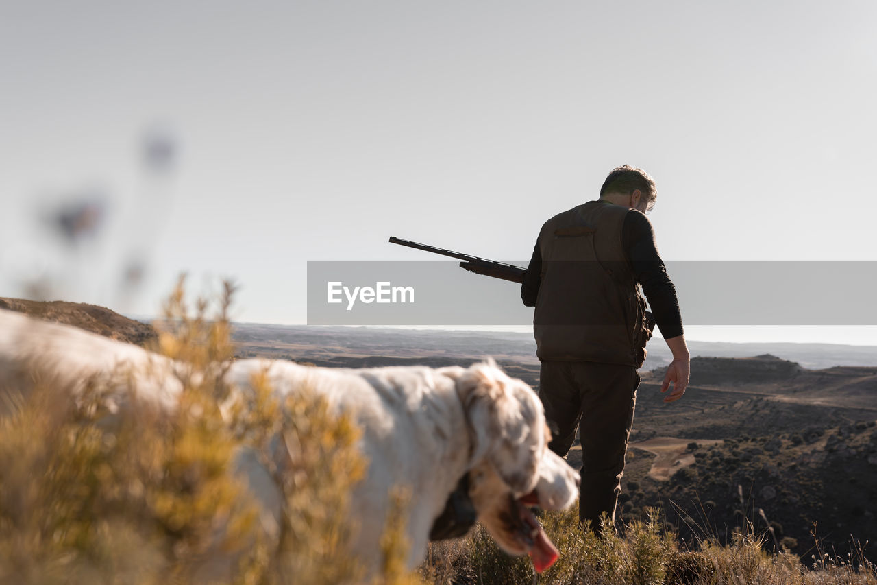 rear view of man with dog on field