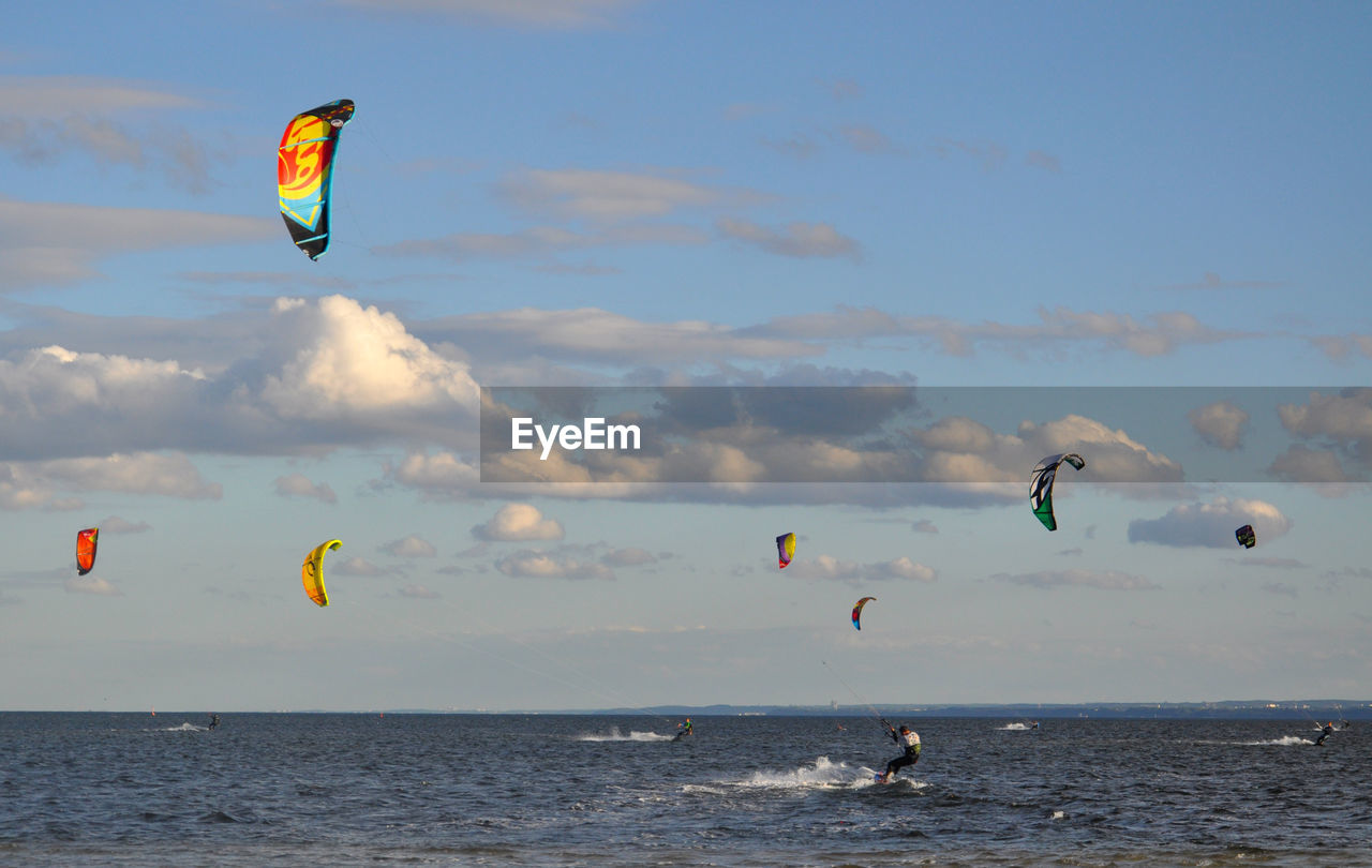 Man kiteboarding on sea against sky