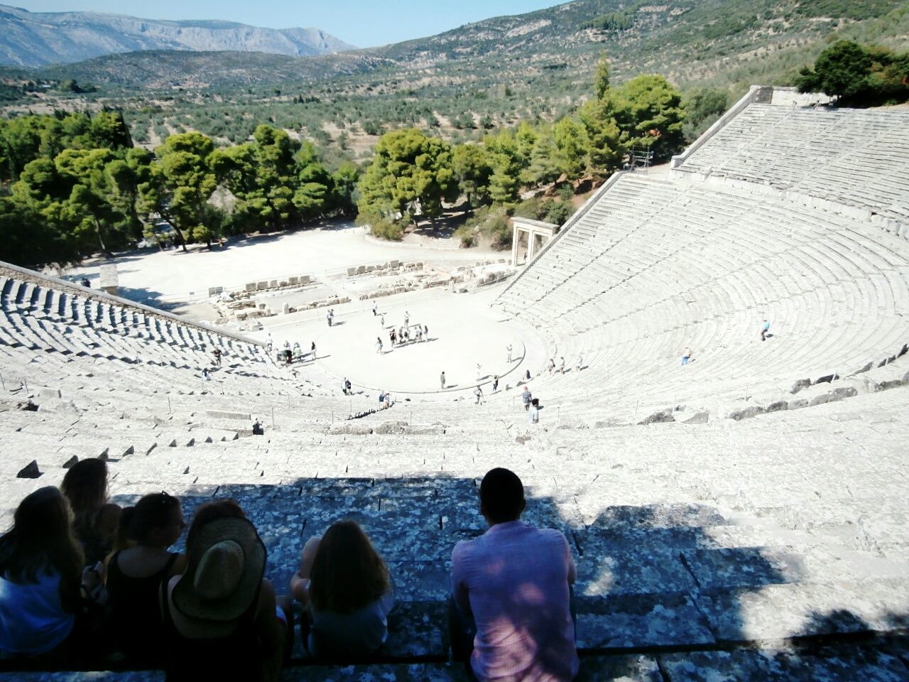 People at the great theatre of epidaurus in city on sunny day