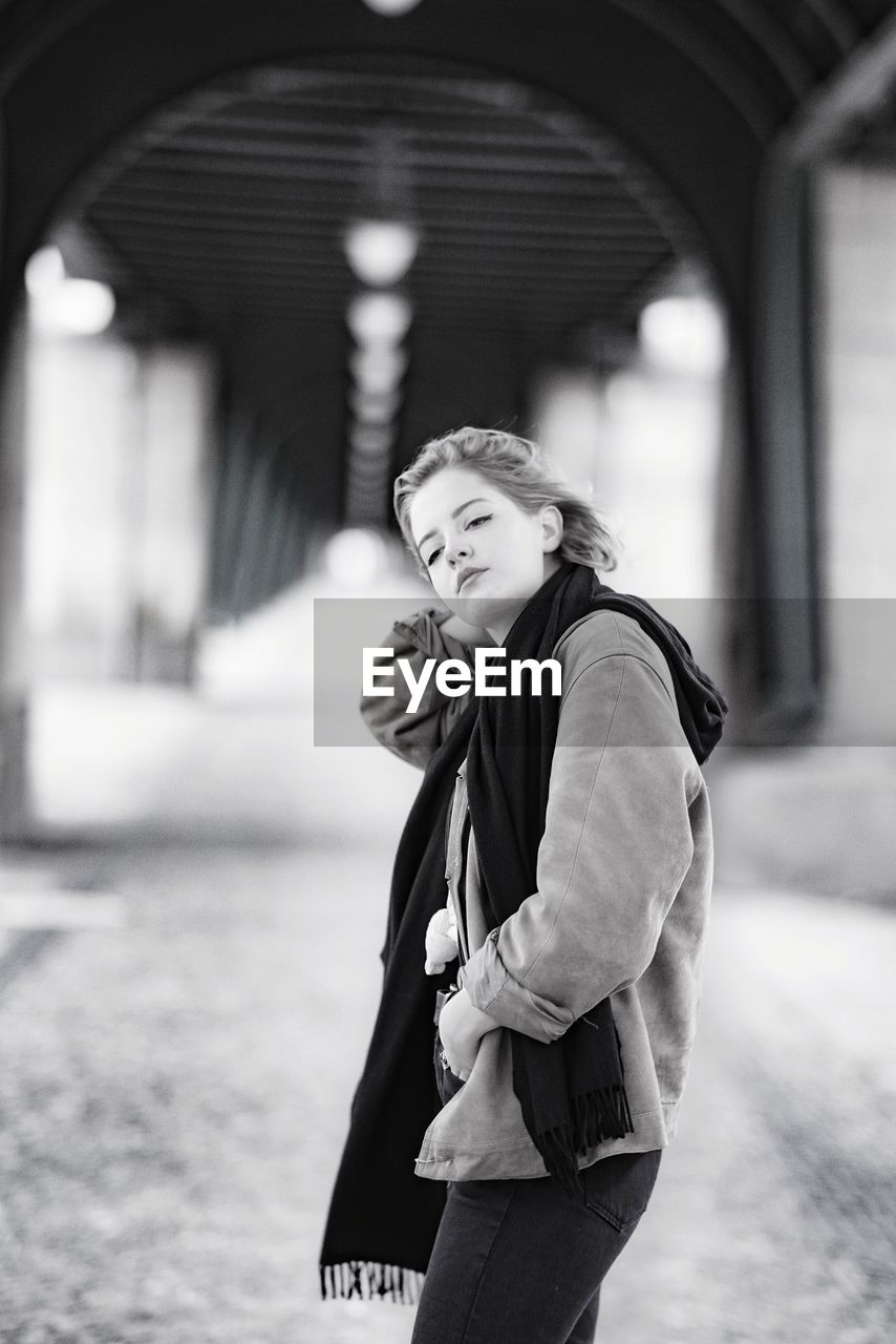 Woman standing under bridge 