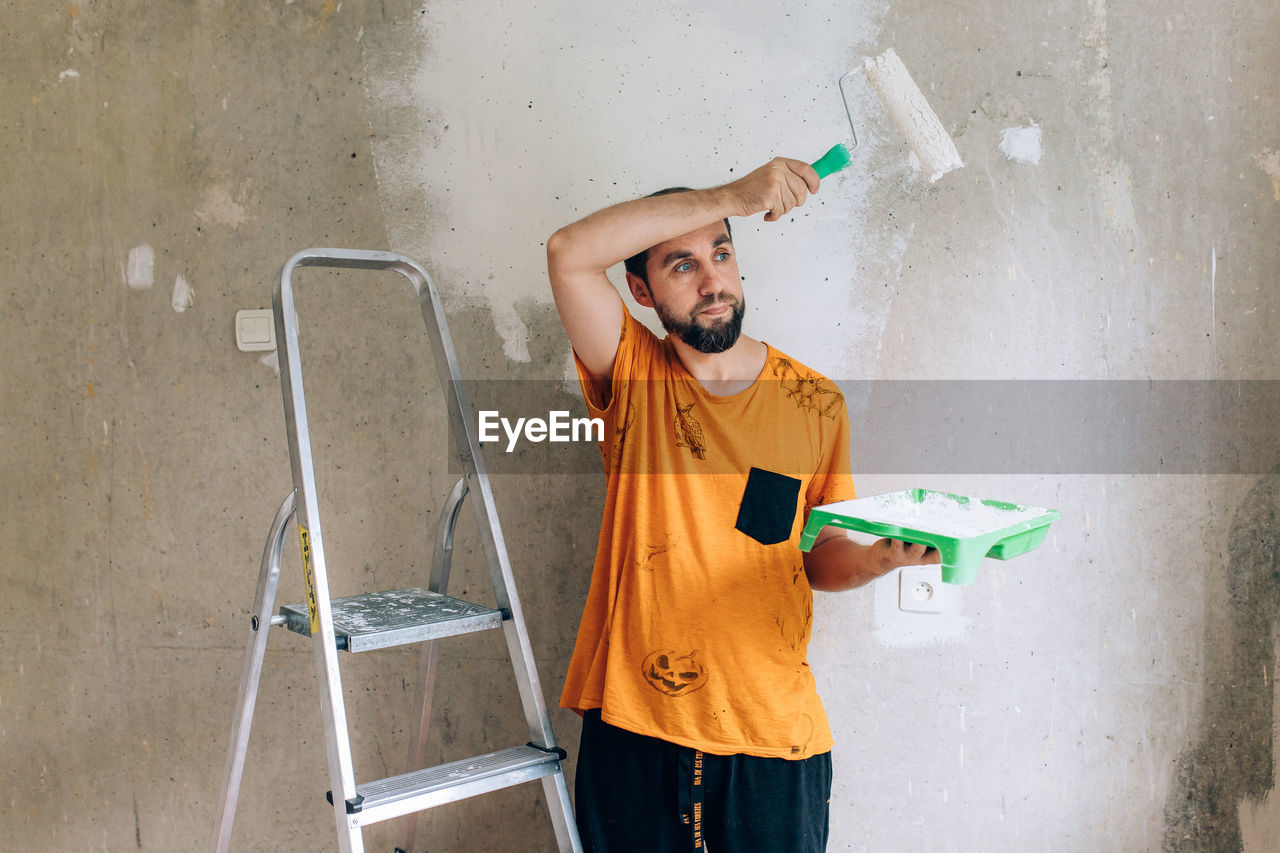 Man painting wall at home