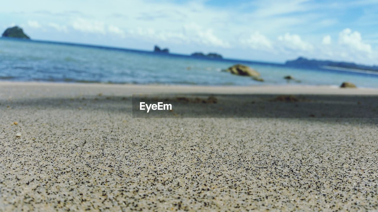 SURFACE LEVEL OF BEACH AGAINST SKY