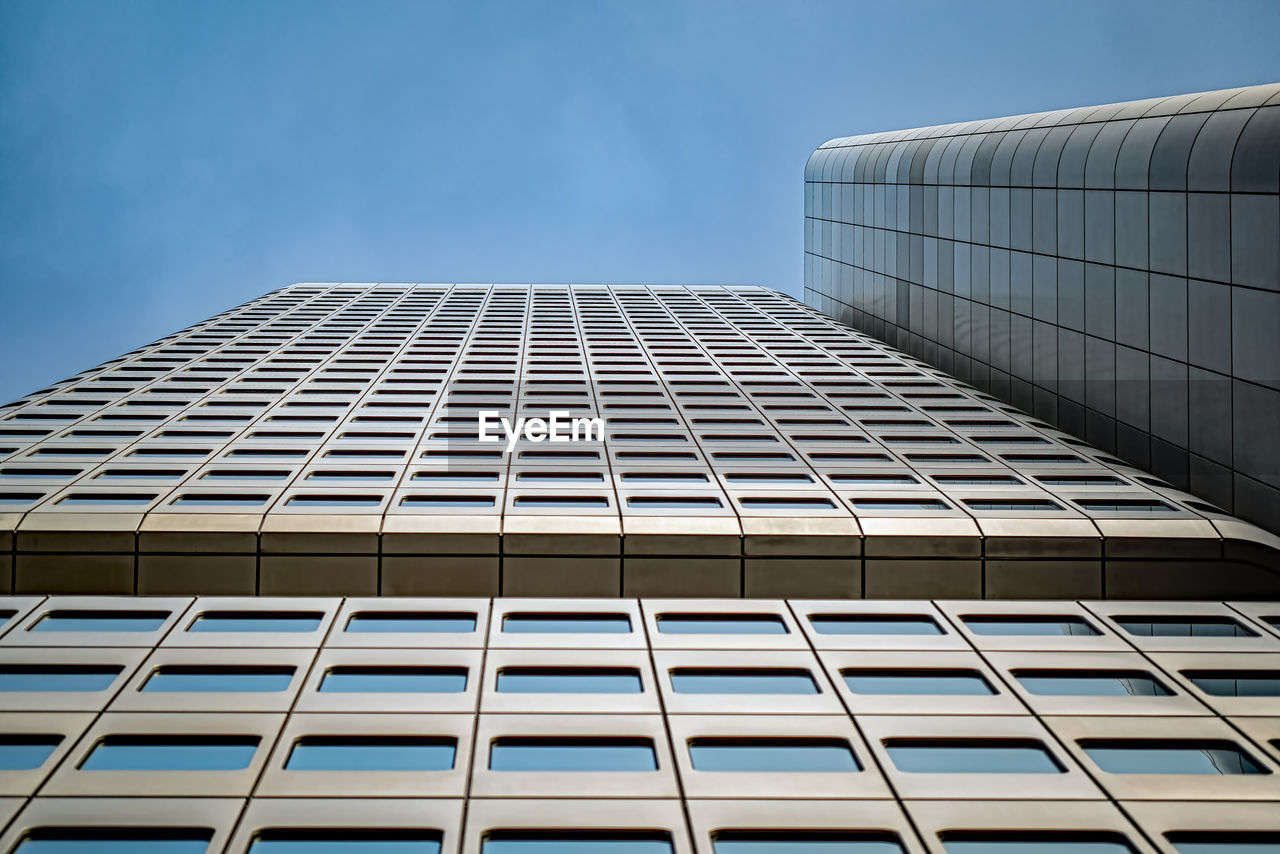 low angle view of modern building against blue sky