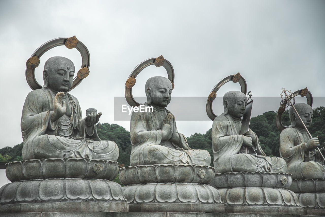 low angle view of statues against sky