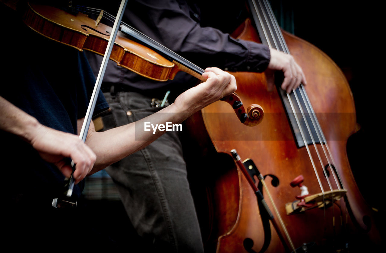 Midsection of men playing musical instruments