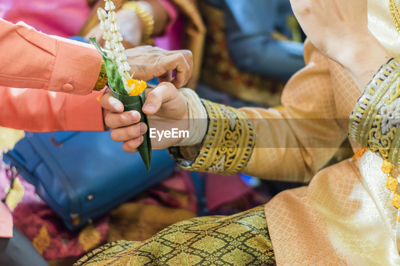 Midsection of woman holding bouquet during wedding festival