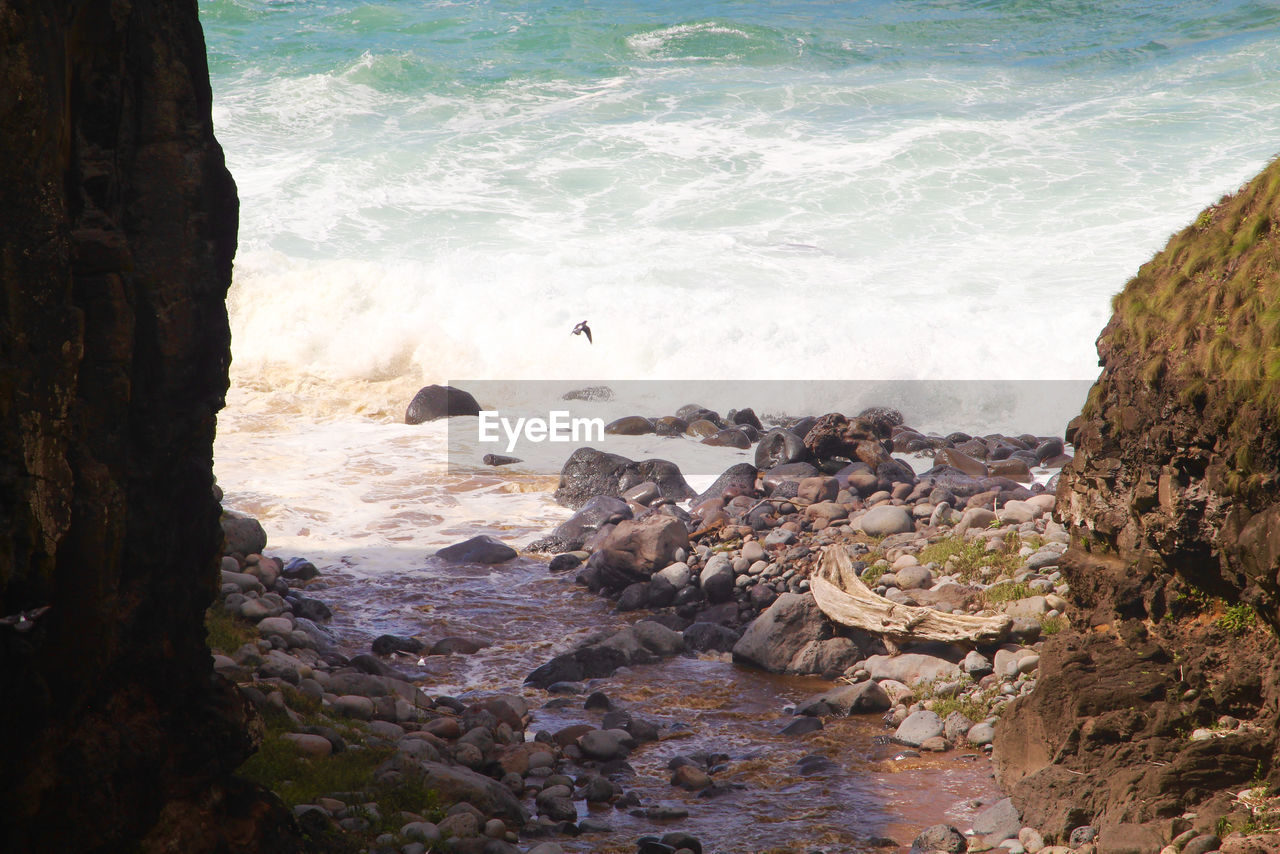 HIGH ANGLE VIEW OF ROCKS AT SEA SHORE