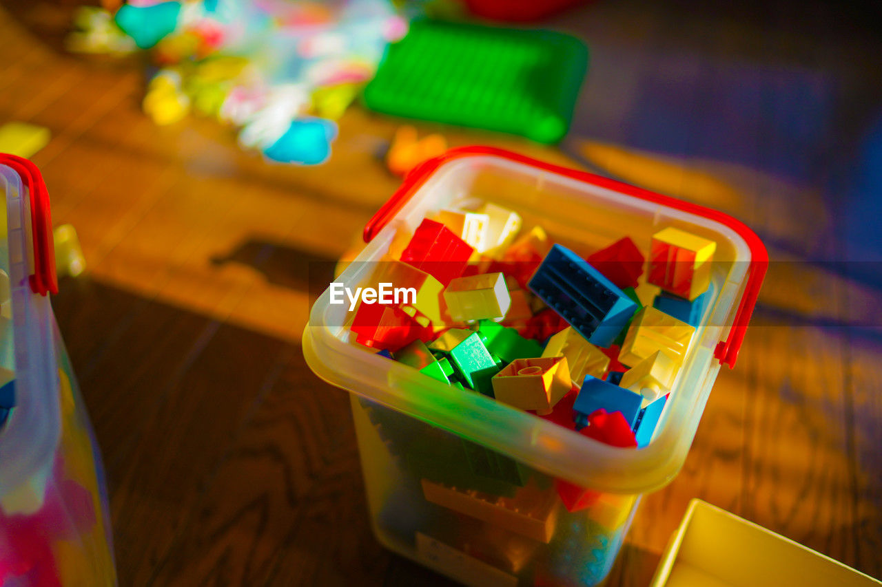 multi colored, toy, table, indoors, container, no people, yellow, focus on foreground, close-up, high angle view