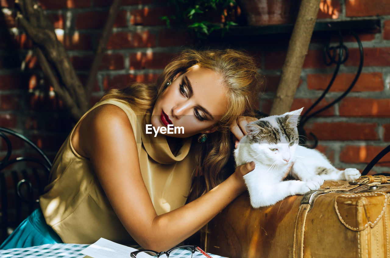 Young woman with cat sitting outdoors