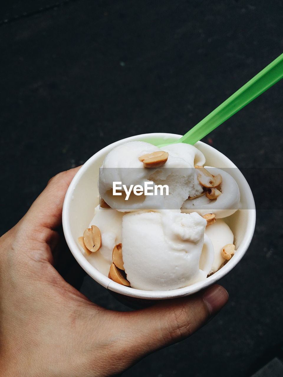 Close-up of hand holding coconut ice cream