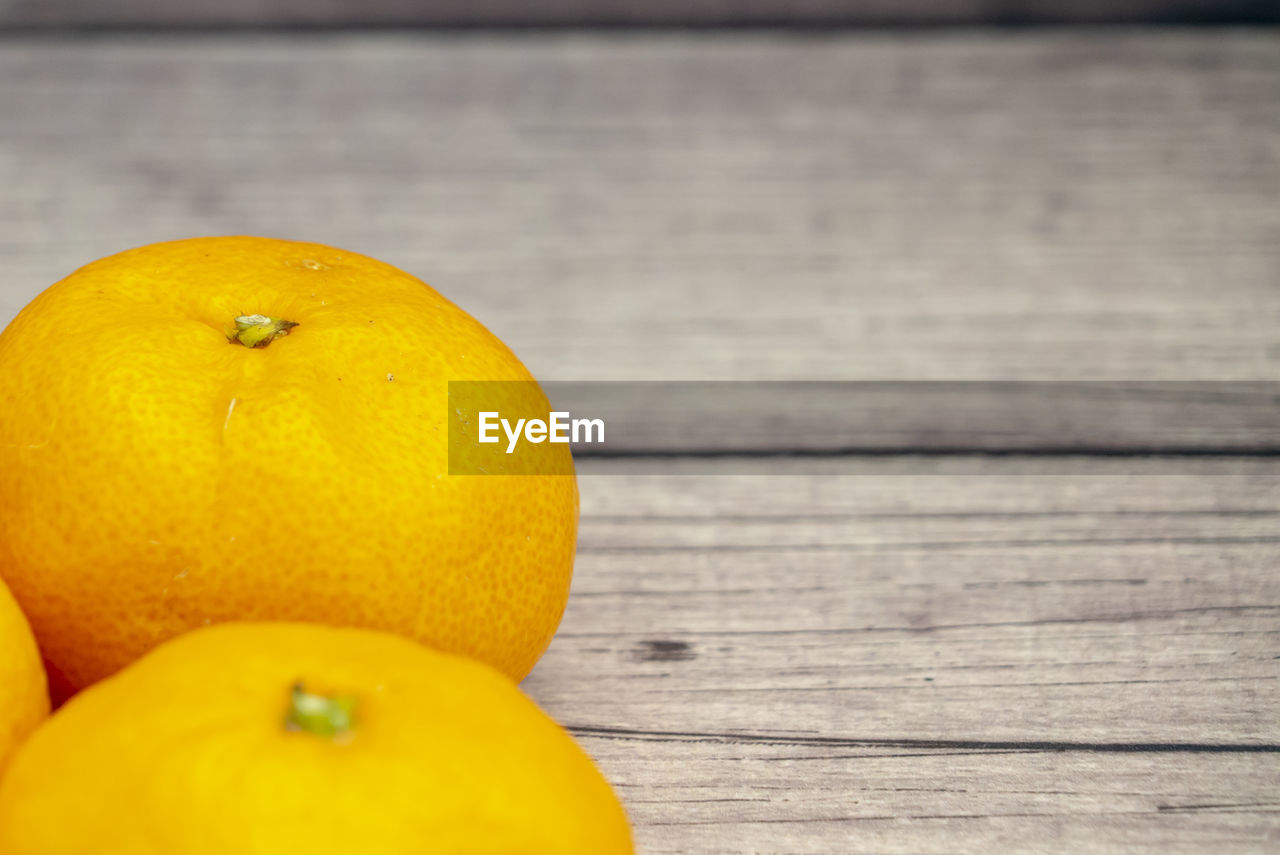 Orange fruit on wooden table background.