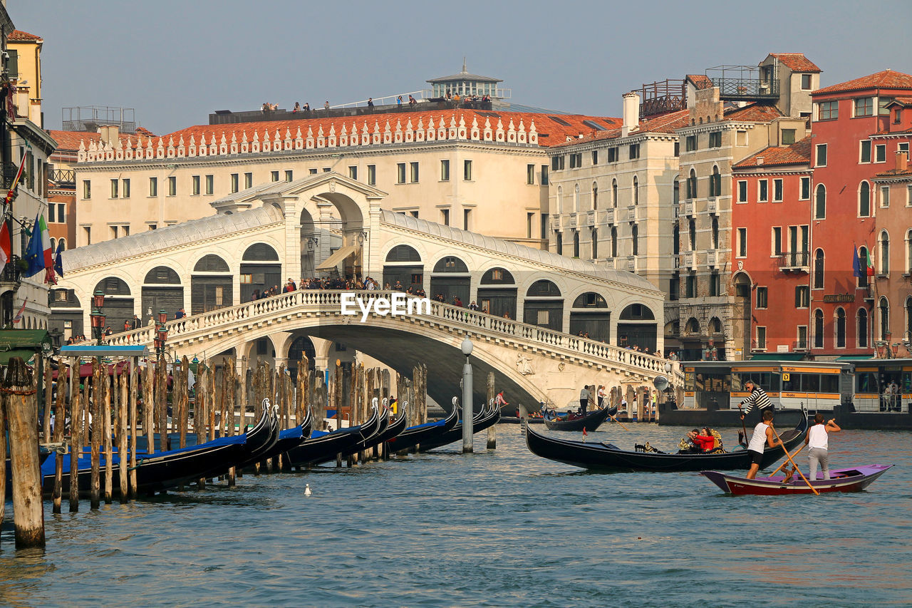 Gondolas, grand canal and rialto bridge in a romantic view of venice.
