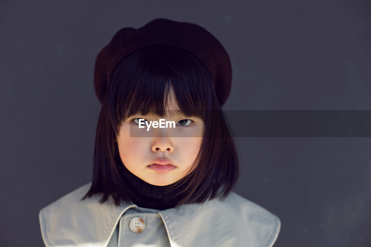 Korean girl in a gray coat and cap and stands the street in spring.