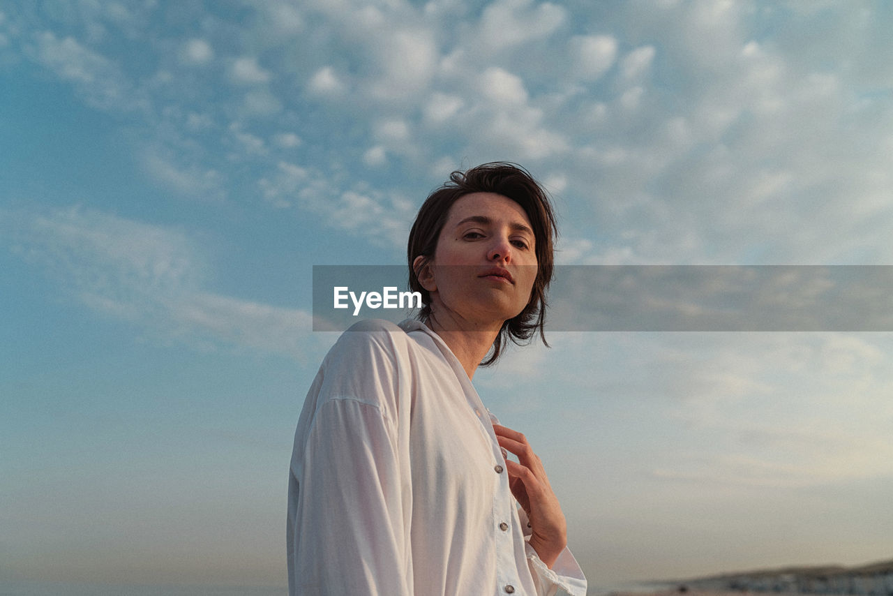 Portrait of woman standing against sky