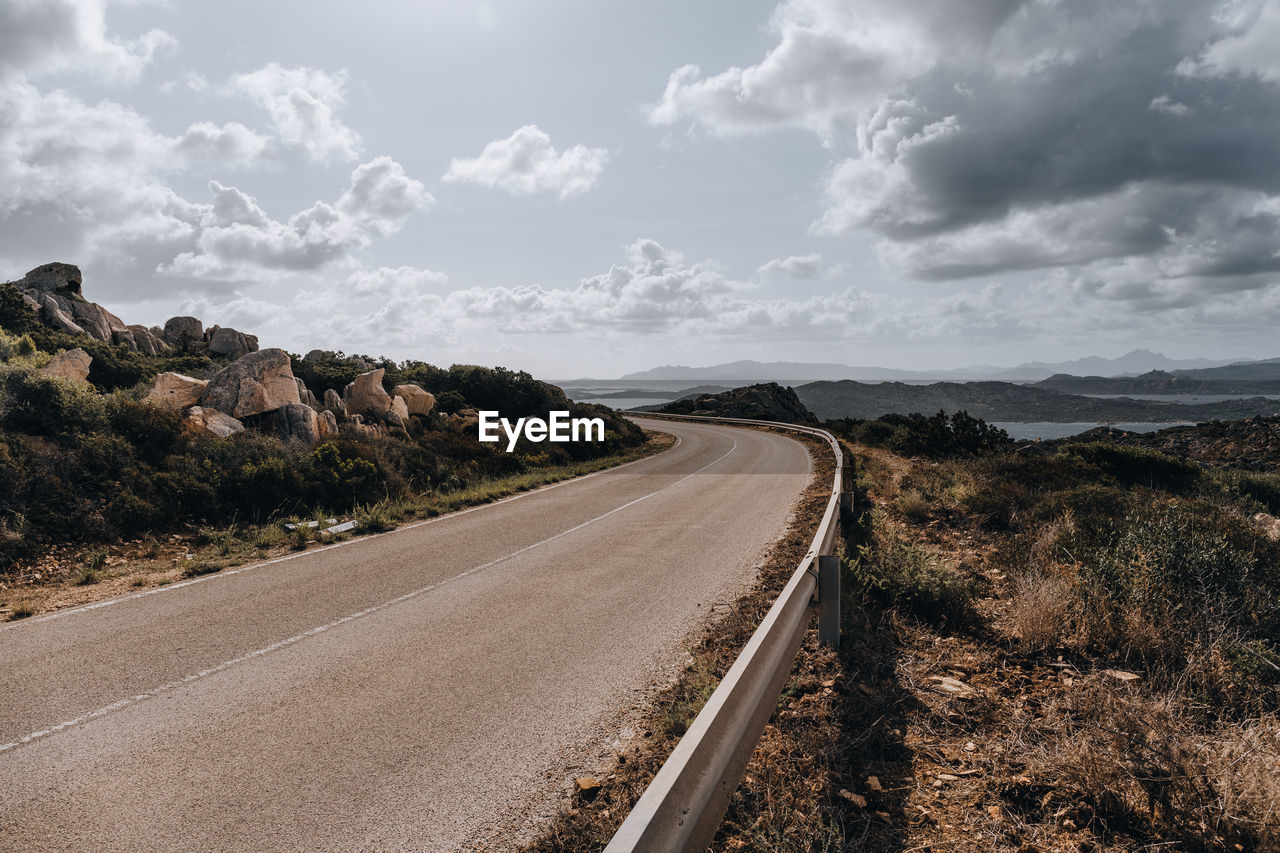 Road leading towards landscape against sky