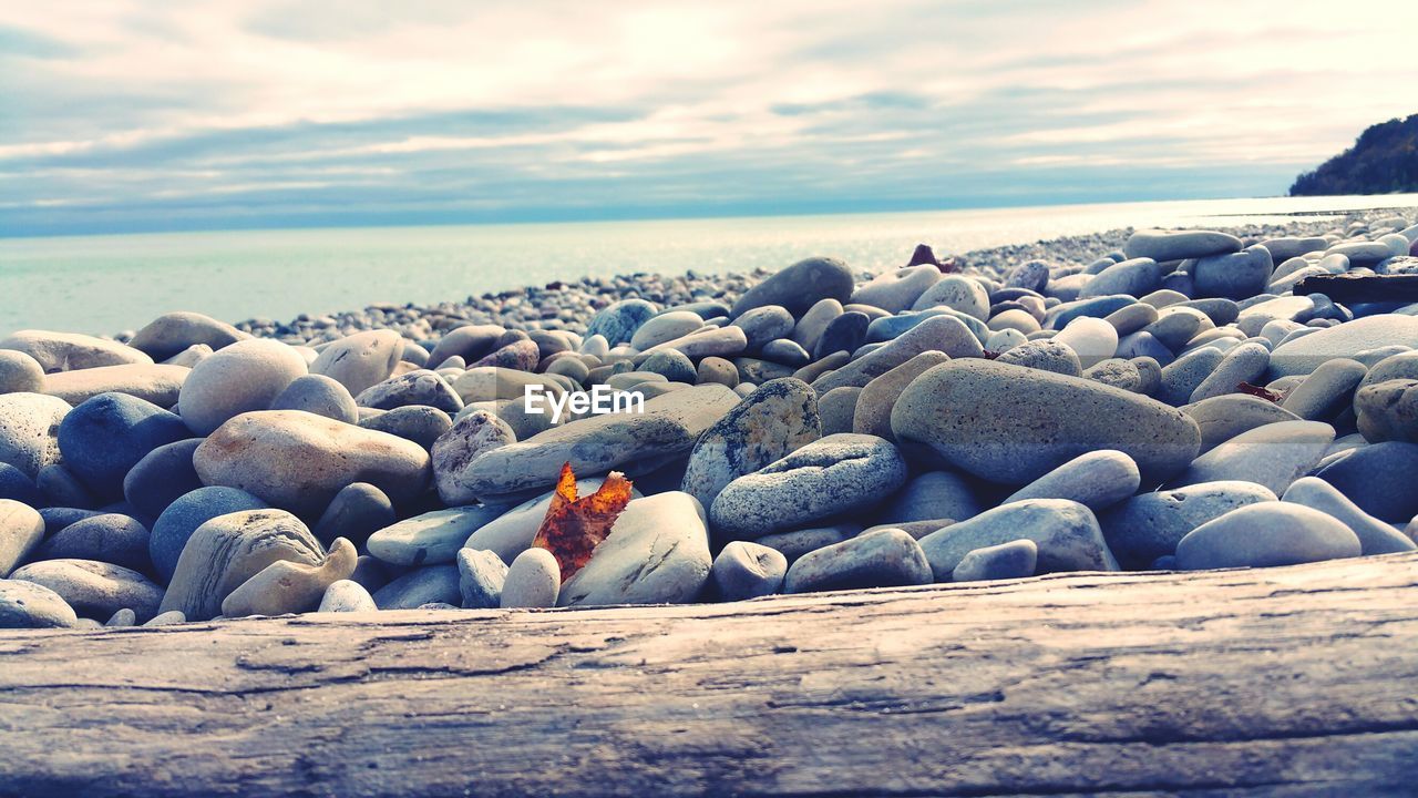 Rocks at beach against sky during sunset