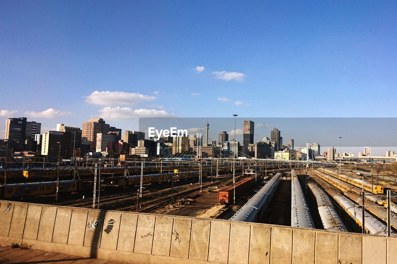 Railroad tracks in city against sky