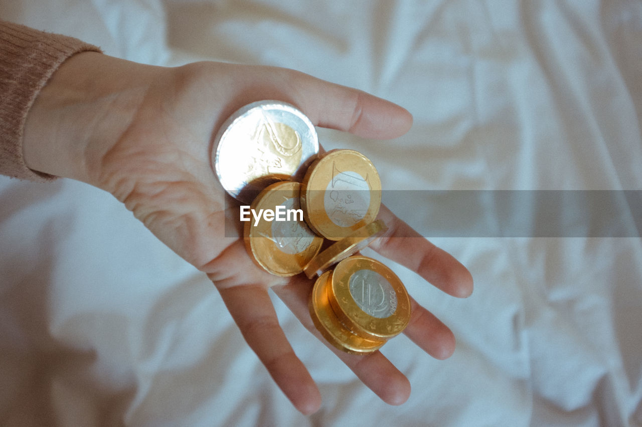 High angle view of hand holding chocolate coins