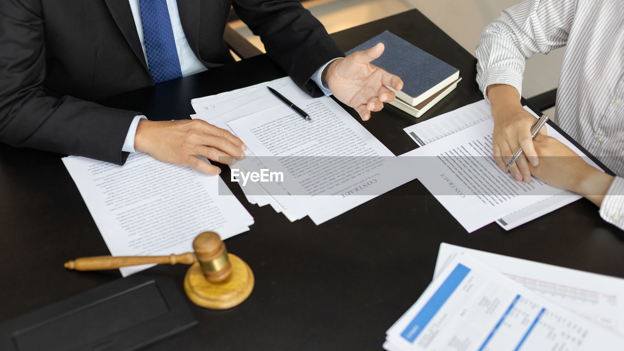 midsection of business colleagues working at table