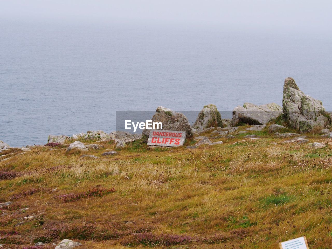 TEXT ON GRASS AGAINST SEA