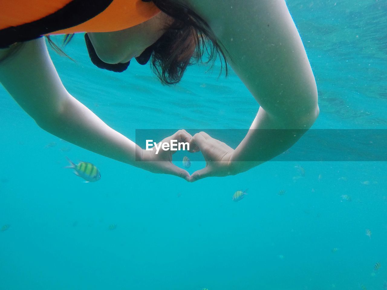 Woman swimming with heart shape undersea