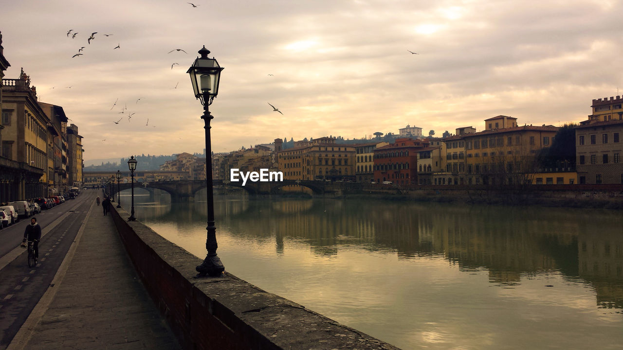 River by city against sky at sunset