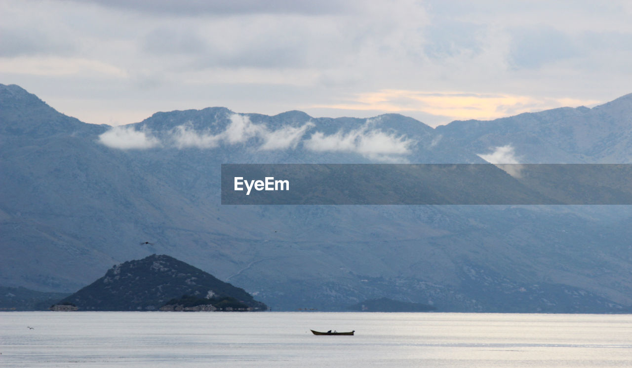 SCENIC VIEW OF LAKE BY MOUNTAINS AGAINST SKY